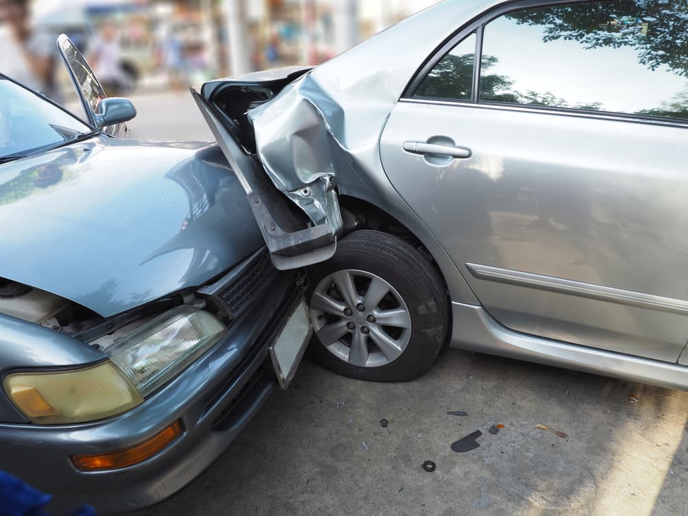 Automobile collision on street with wrecked and damaged cars. Accident due to negligence and inability to drive.