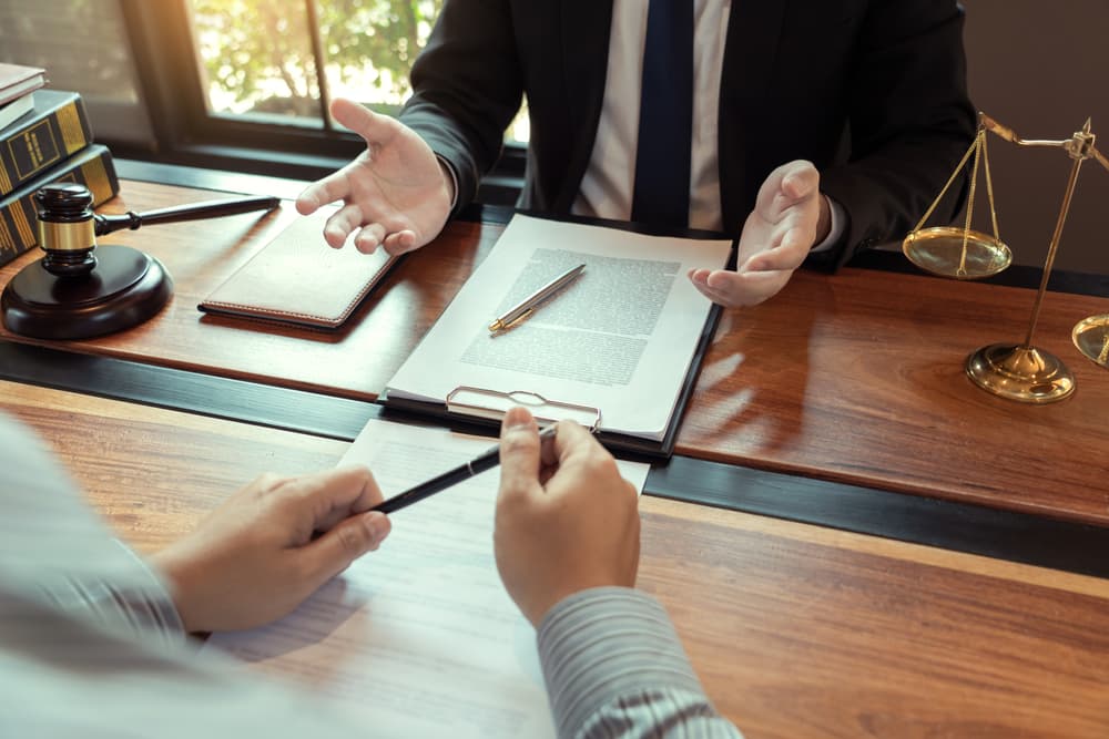 A DWI defense attorney consults with a client across a desk.