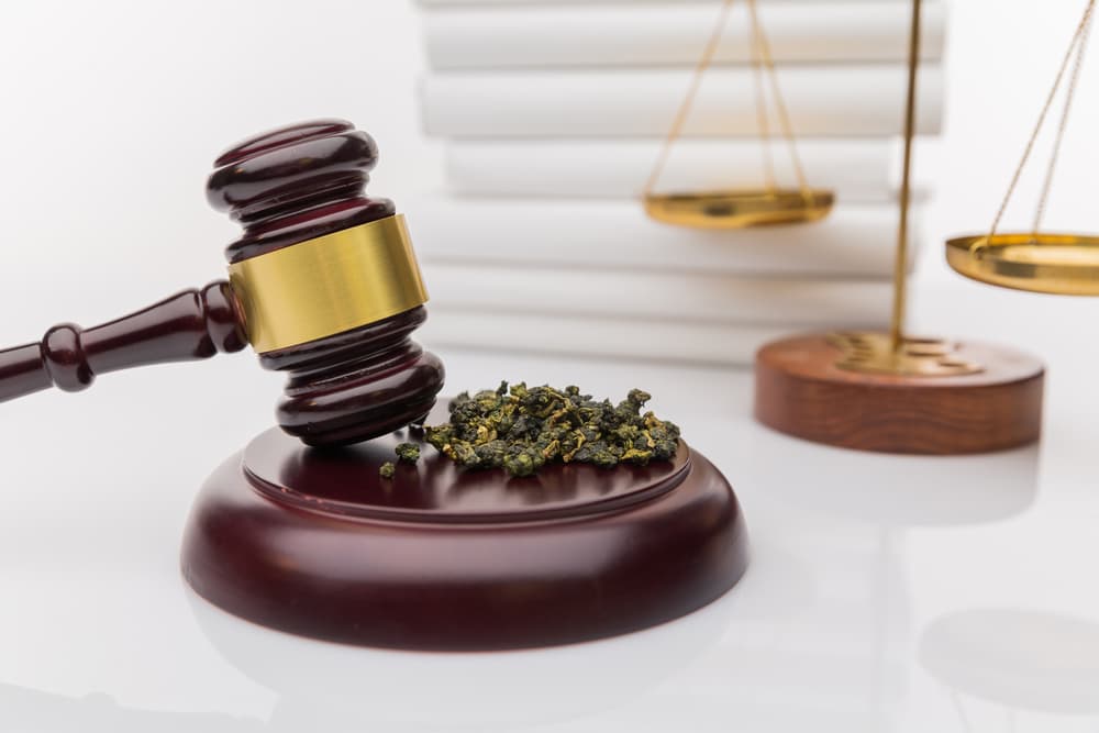 Gavel and marijuana on scales symbolizing drug possession law in San Angelo.