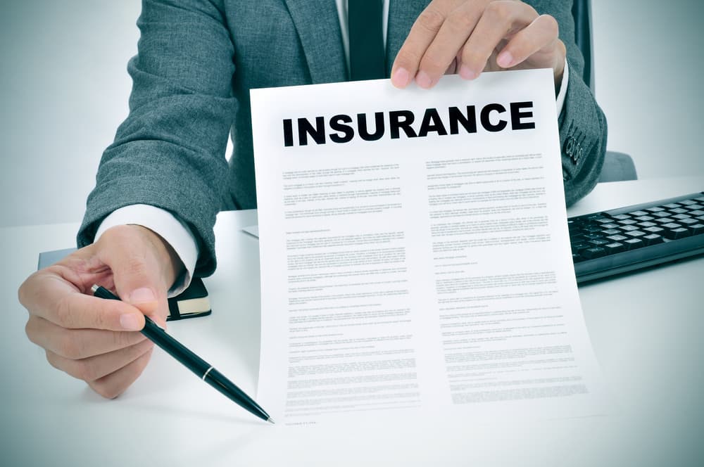 person holding insurance form with a pen