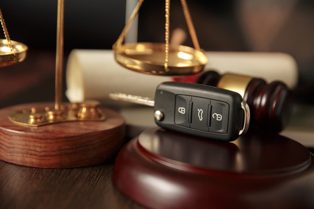 car key on gavel next to scales of justice