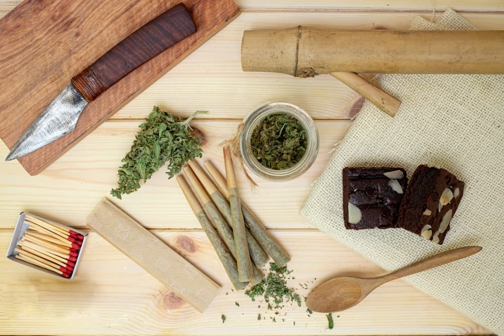 Marijuana with drug paraphernalia on wooden background