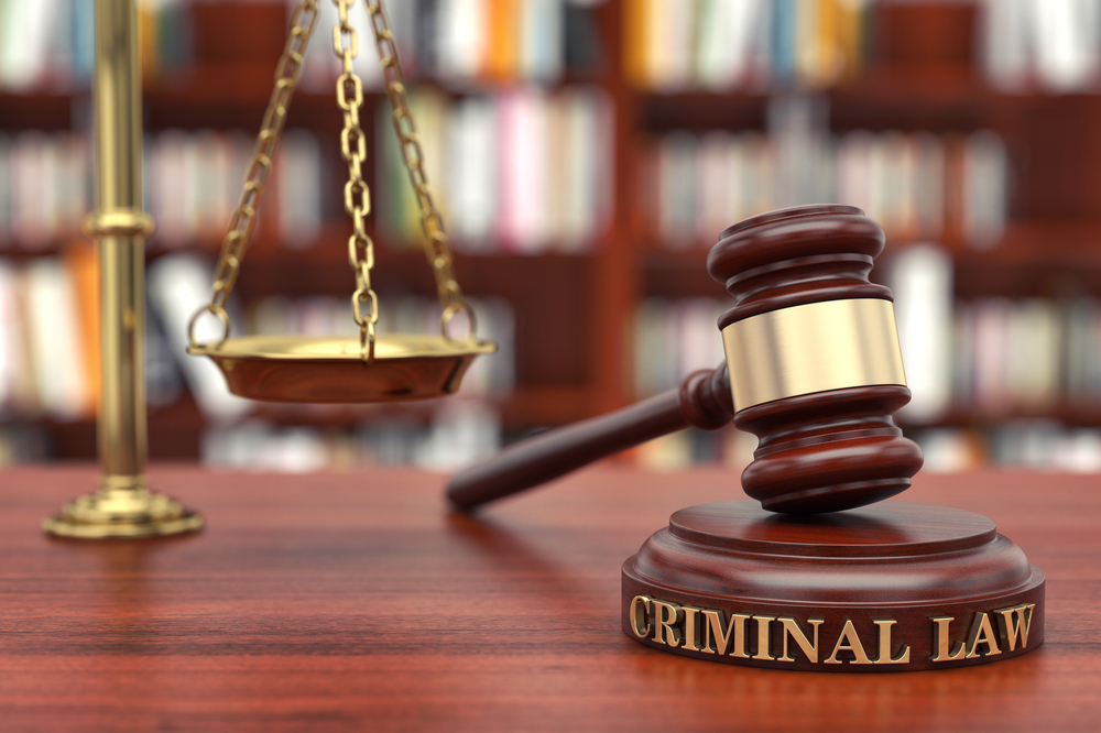Gavel resting on a law book representing criminal law and justice system