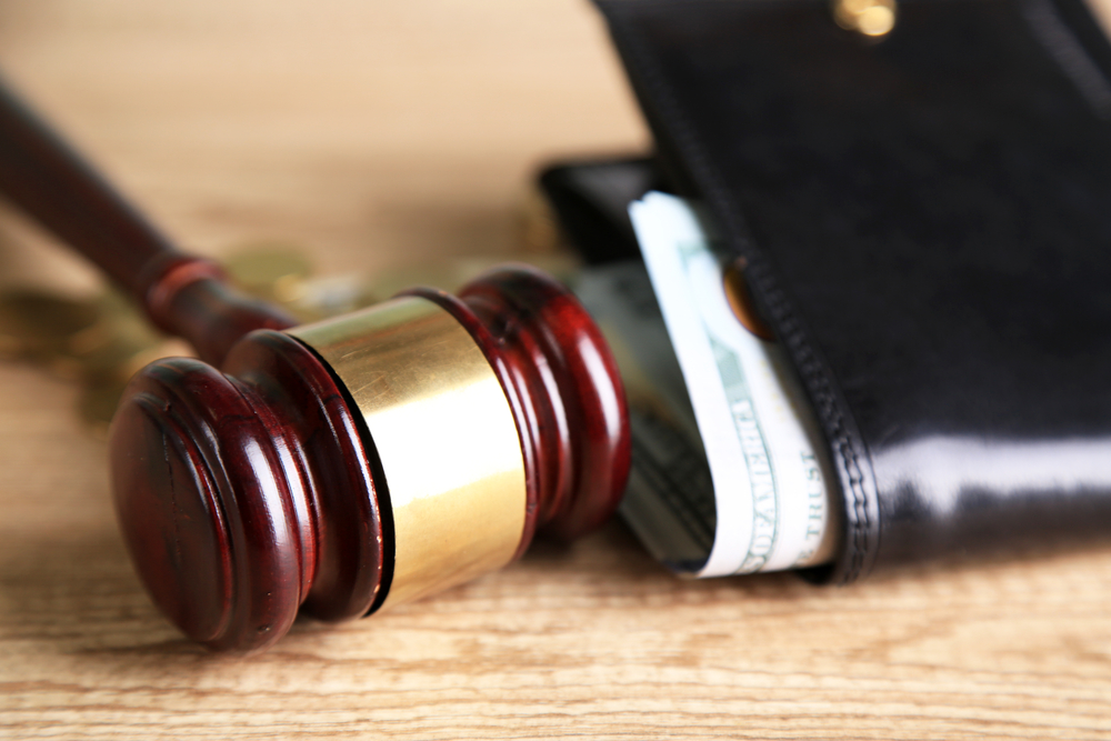 Court gavel beside wallet with cash representing personal injury compensation