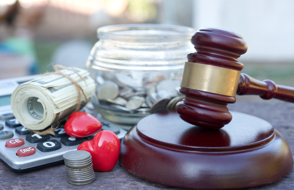 Judge’s gavel with calculator, money, and coins symbolizing personal injury lawyer costs.
