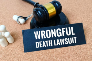 Judge’s gavel beside a sign reading wrongful death lawsuit on cork background