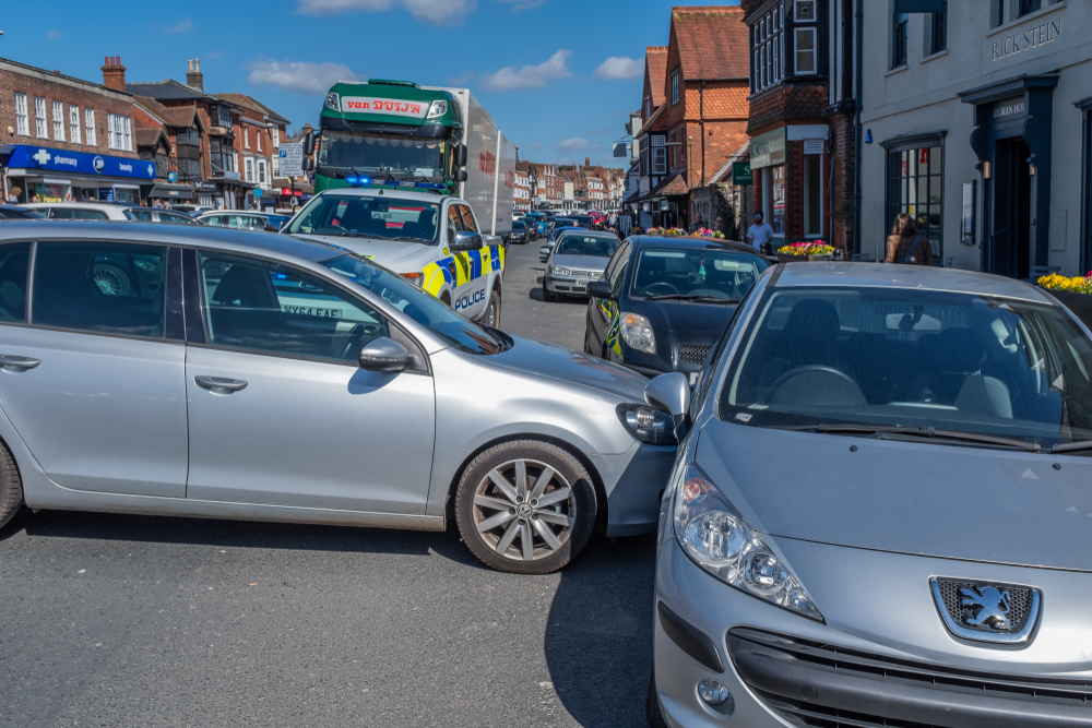 Traffic halted as officers investigate a T-bone crash between two vehicles on a city street.