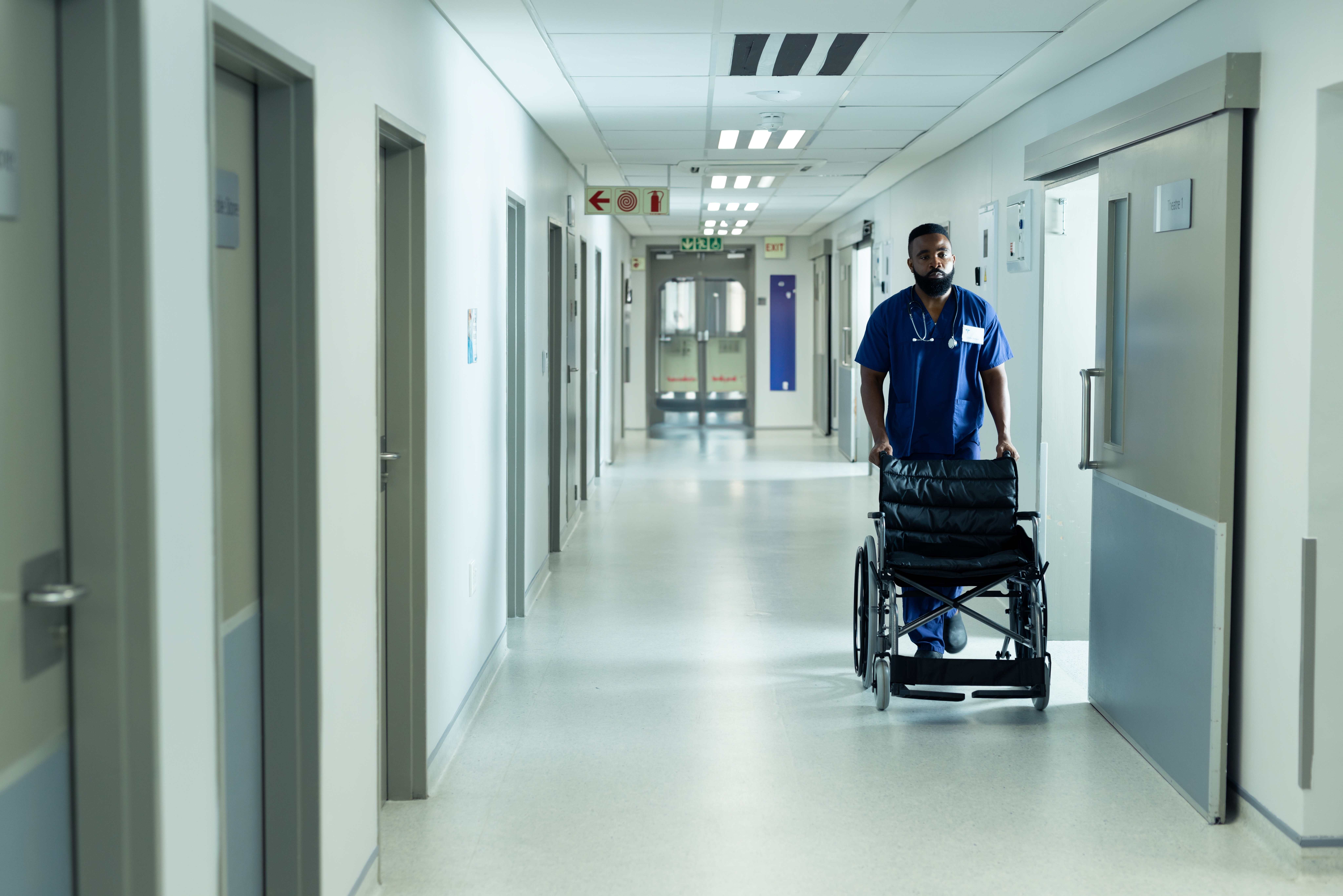 Empty hospital hallway with patient room doors
